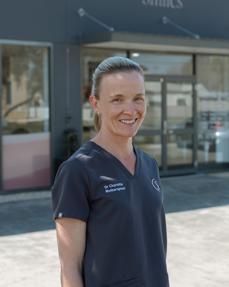 Dr Charlotte Wotherspoon, principal dentist at Singleton Smiles, smiling in dark grey scrubs